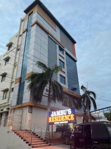 a tall building with a sign in front of it at jambu's residence in Karūr