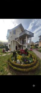 a large house with a flower garden in front of it at Andrea Airport Apartments in Belgrade