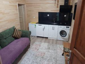 a living room with a couch and a washing machine at Haros Apart Hotel in Uzungöl