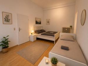 a living room with two beds and a couch at City Rooms Koblenz Hbf in Koblenz +12 photos