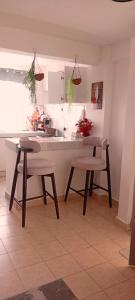 una cucina con un tavolo, due sedie e un bancone di The Amber Homes a Meru