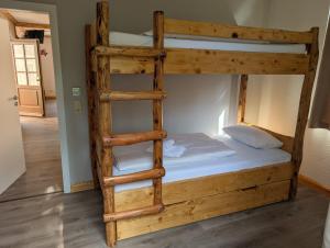 a wooden bunk bed with a ladder in a room at Pension Bomätscher in Königstein an der Elbe +49 photos