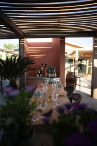 a long table with wine glasses and purple flowers at Blendin Retreat Agde in Le Grau-dʼAgde