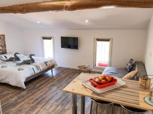 a bedroom with a bed and a table with a bowl of fruit at Studio charmant à Saint-Jory, 25 m², piscine partagée in Saint-Jory