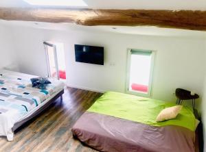 a bedroom with a bed and a tv on the wall at Studio charmant à Saint-Jory, 25 m², piscine partagée in Saint-Jory