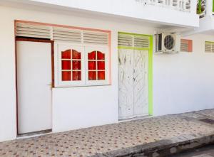 a white house with two doors and a window at Studio confortable à Capesterre-de-Marie-Galante - 20 m² in Capesterre