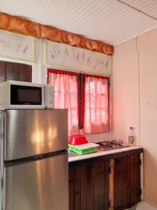 a kitchen with a stainless steel refrigerator and a microwave at Studio confortable à Capesterre-de-Marie-Galante - 20 m² in Capesterre