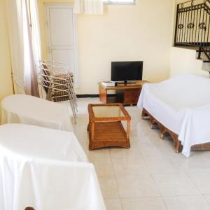 a room with two beds and a table and a television at Elegant Apartment in Trou aux Biches / 125 m² / Mountain View in Trou aux Biches