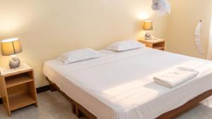 a bedroom with a large white bed with two night stands at Elegant Apartment in Trou aux Biches / 125 m² / Mountain View in Trou aux Biches +11 photos