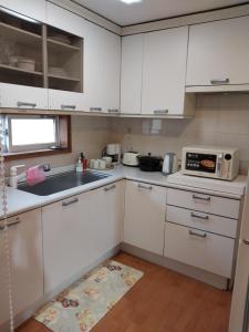 a kitchen with white cabinets and a sink at Art Residency in Busan +15 photos
