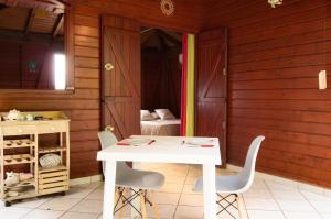 a white table and chairs in a room with wooden walls at Bungalow charmant au Gosier in Le Gosier