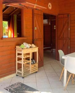 a room with wooden doors and a table and chairs at Bungalow charmant au Gosier in Le Gosier +8 photos