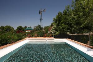 a swimming pool in a backyard with a table and chairs at Quinta Da Praia Das Fontes in Alcochete