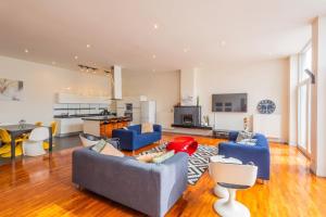 a living room with blue couches and a kitchen at Spacious House with Large Garden in Jette in Brussels