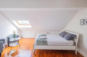 a white bedroom with a bed and a table at Spacious House with Large Garden in Jette in Brussels +20 photos
