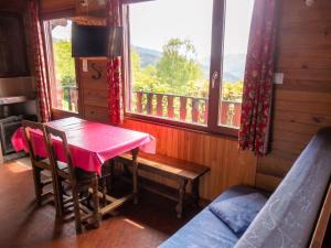 a dining room with a pink table and a window at Chalet charmant au Tholy avec piscine partagée in Le Tholy