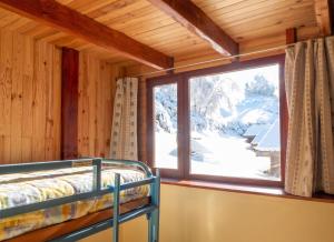 a room with a bed and a large window at Chalet charmant au Tholy avec piscine partagée in Le Tholy