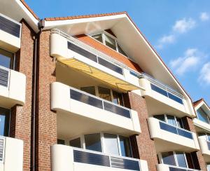 a building with white balconies on the side of it at Haus Trafalgar App 255 in Cuxhaven