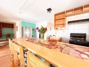 a kitchen with a table with a vase of flowers on it at Prince and Pooch Self Catering in Windhoek