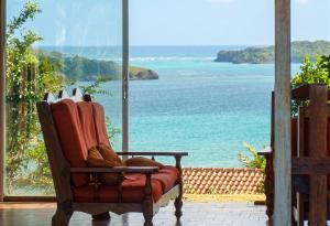 a chair sitting in a room with a view of the ocean at Maison spacieuse avec piscine privée à Le François in Le François