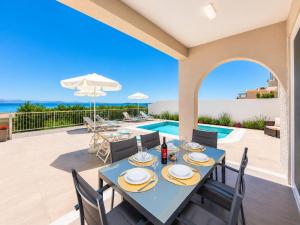 a dining room with a table and chairs and a swimming pool at Villa Alora in Barbati