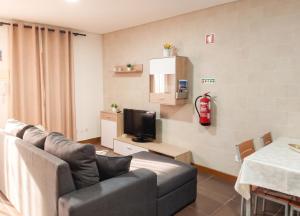 a living room with a couch and a fire extinguisher on the wall at Comfortable House in Marinhas + Garden and Sea View. in Marinhas