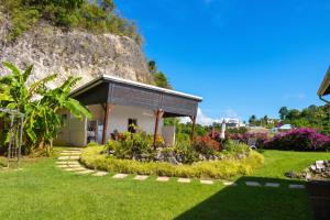 a small house with a garden in front of a hill at Villa cosy avec piscine privée - Le Gosier. in Le Gosier