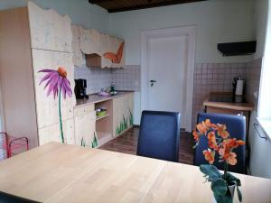 a kitchen with a table with a flower on the wall at Pension Bomätscher in Königstein an der Elbe