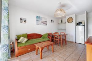 a living room with a couch and a table at Appartement chez Coco avec piscine in Soulac-sur-Mer