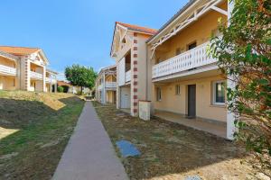 a sidewalk in front of a row of houses at Appartement chez Coco avec piscine in Soulac-sur-Mer