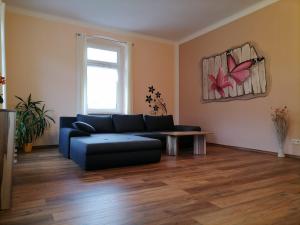 a living room with a blue couch and a table at Pension Bomätscher in Königstein an der Elbe