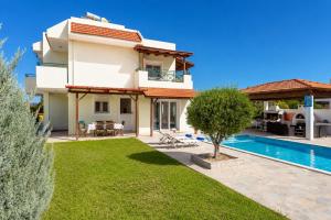a villa with a swimming pool and a yard at Hermione Villa in Gennadi