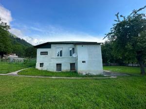 a small white house in a field of grass at Guest House Babi in Letsperi