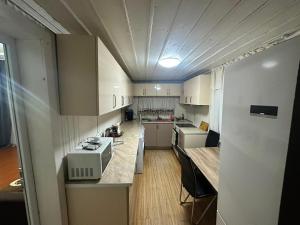 a small kitchen with white cabinets and a microwave at Guest House Babi in Letsperi