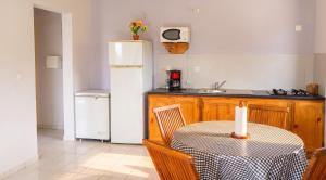 a kitchen with a table and a white refrigerator at Appartement confortable à Capesterre, 40 m², jardin agréable in Rabi