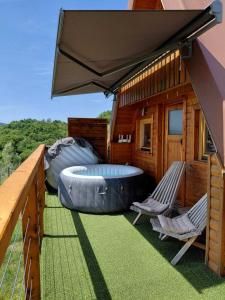 a hot tub on the deck of a house at Glamping Čelig in Donja Višnjica
