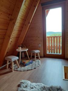 a room with a table and two chairs and a window at Glamping Čelig in Donja Višnjica +16 photos