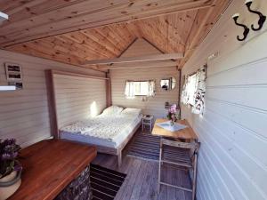 a bedroom in a tiny house with a bed and a table at Sandvikengården Stugby in Edane
