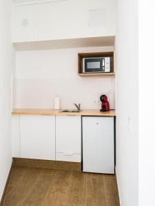 a kitchen with white cabinets and a microwave at A Calexa Sarria nº1 in Sarria