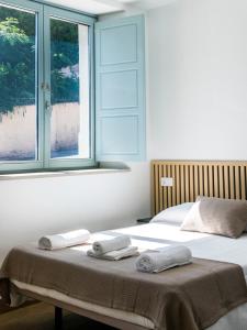 a bedroom with a bed with two towels on it at A Calexa Sarria nº1 in Sarria