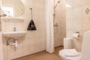 ein Badezimmer mit Waschbecken, Toilette und Dusche in der Unterkunft Hotel Phønix Aalborg in Aalborg