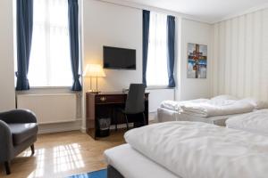 ein Hotelzimmer mit zwei Betten und einem Schreibtisch mit Computer in der Unterkunft Hotel Phønix Aalborg in Aalborg