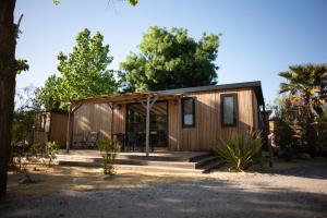 a small wooden cabin with a porch and trees at Blendin Retreat Agde in Le Grau-dʼAgde