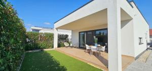 a house with a deck with a table and chairs at Alexandra Nesvady in Nesvady
