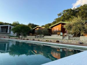 a house with a swimming pool in front of a house at Casa Mila apartments & bungalows in Ulcinj