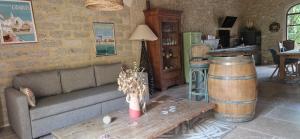 a living room with a couch and a table and a barrel at La Remise in Vergèze