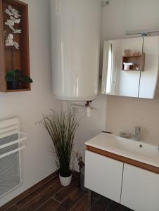 a white kitchen with a sink and a mirror at La Tantonnière in Romagny