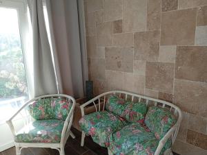 a living room with two chairs and a couch at La Tantonnière in Romagny