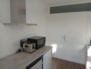 a kitchen with a counter top with a tv on it at La Tantonnière in Romagny
