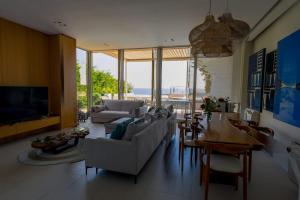 a living room with couches and a table and a television at Vila IL SOLE GREEN COAST in Palasë